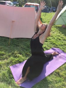 yoga between the tents at a campsite