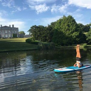 shoulderstand on a paddleboard at kingston maurward