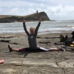 woman doing yoga on rocks by the sea