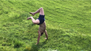 man doing a handstand in a field