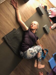 woman doing a yin yoga twist in studio